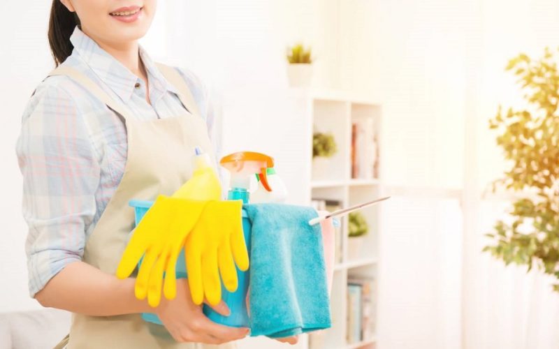 femme avec fournitures de nettoyage prête à faire le ménage à domicile