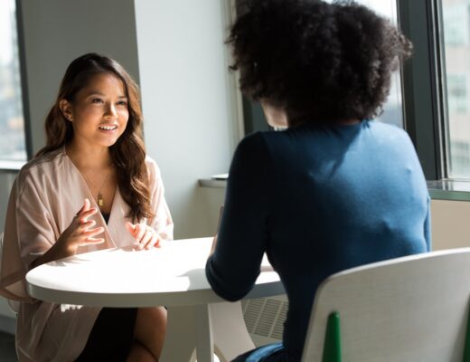two women sitting on chair