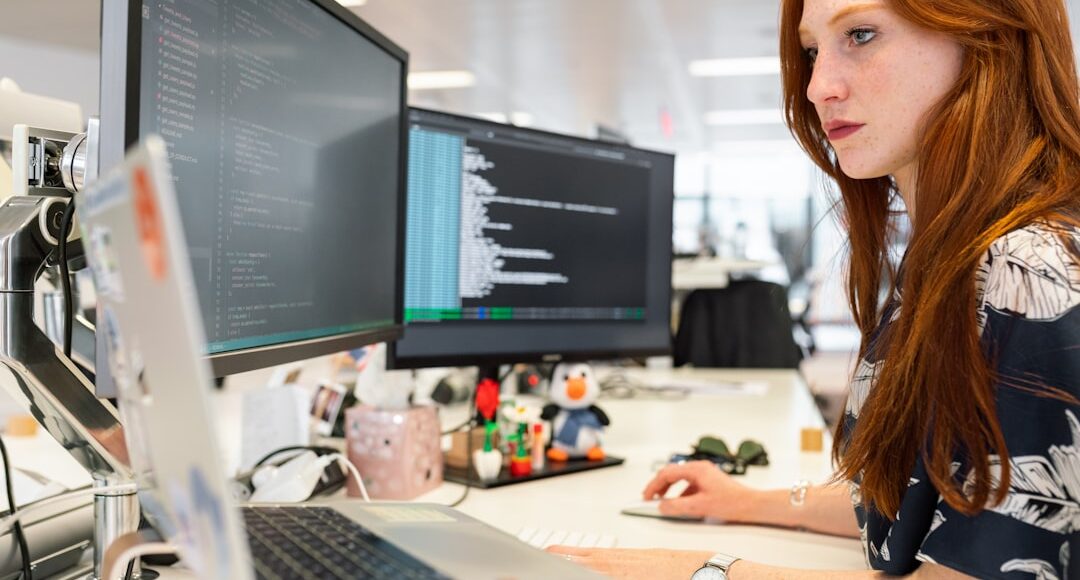 woman in green shirt sitting in front of computer