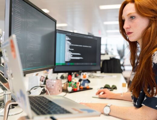 woman in green shirt sitting in front of computer