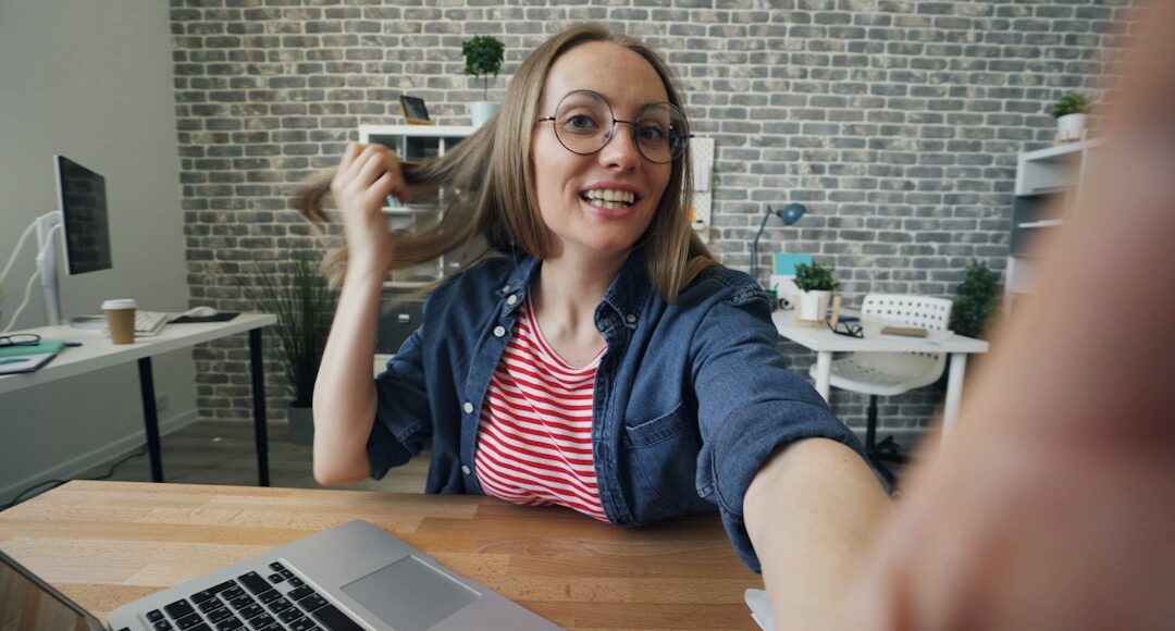 a woman sitting at a table in front of a laptop computer
