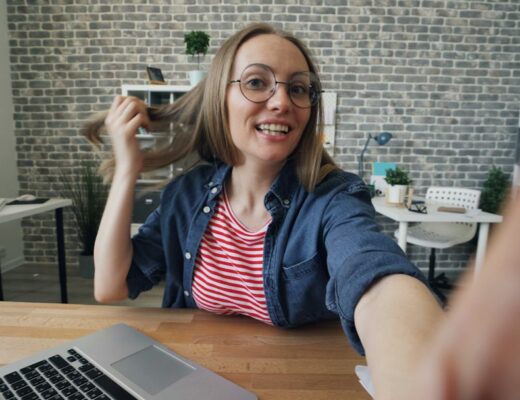 a woman sitting at a table in front of a laptop computer