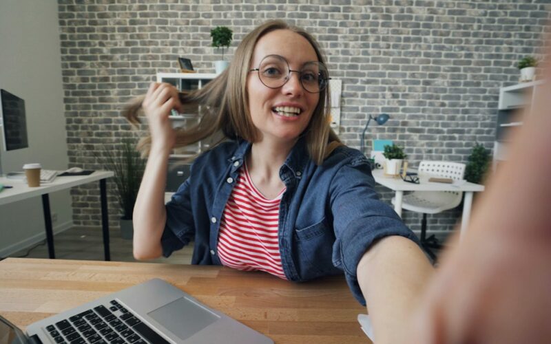 a woman sitting at a table in front of a laptop computer